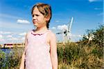 5 year old girl standing in a field near a harbor on a sunny day, Germany