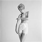 1960s PORTRAIT TOPLESS BLONDE WOMAN WEARING GIRDLE LINGERIE LEFT ARM CROSSED IN FRONT OF CHEST