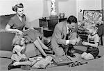 1940s FAMILY FATHER MOTHER DAUGHTER SON TOGETHER IN LIVING ROOM WITH TOY ERECTOR SET