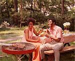 1970s SMILING AFRICAN AMERICAN COUPLE MAN WOMAN DRINKING BEER AT BACKYARD BARBECUE