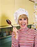 1970s LAUGHING WOMAN CHARACTER WEARING CHEF HAT TOQUE STRIPED RED WHITE SHIRT HOLDING COOKING SPOON LOOKING AT CAMERA