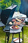 Sausages, skewers and vegetables on a charcoal barbecue