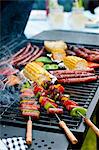 Sausage kebabs, sausages and vegetables on a barbecue