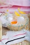 Fresh eggs with feathers in a wire basket