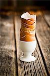 A stack of empty egg shells in an egg cup