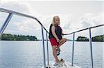 Boy Standing on Nose of Boat on Lake, Sweden