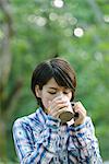 Young Japanese woman drinking coffee at a camp site