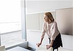 Pensive businesswoman looking out office window