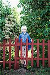 Young girl standing behind fence