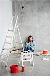 Young woman surrounded with paint supplies