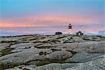 Lighthouse on rock against sky