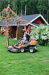 Mother with son on ride-on lawn mower