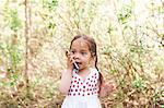 Toddler girl talking on cell phone in park
