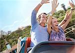 Exhilarated young couple riding amusement park ride