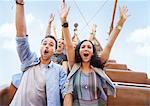 Portrait enthusiastic friends cheering on amusement park ride