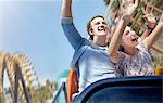 Enthusiastic couple cheering and riding amusement park ride