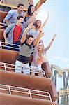 Enthusiastic friends cheering on amusement park ride