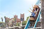 Enthusiastic friends cheering on log amusement park ride