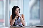 Pensive businesswoman looking away in conference room