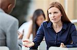 Businesswoman gesturing and talking to businessman