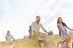 Family bike riding in sunny rural field