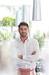 Portrait confident waiter with arms crossed in cafe