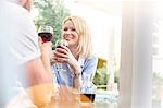 Smiling couple drinking wine and talking at cafe