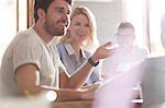 Smiling parents talking and gesturing to daughter at cafe