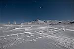 Starry sky over snow covered mountains in the wintertime