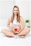 Young pregnant woman relaxing on the bed