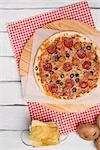 Italian pizza served on wooden table, close-up.