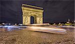 Night time in Arc de Triomphe and blurred cars traffic along the traffic circle