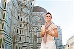 An amble around awe-inspiring Duomo in Florence, Italy. Happy woman tourist standing in the front of Duomo and looking into the distance