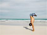 Mature man doing handstand on beach, South Pointe Park, South Beach, Miami, Florida, USA