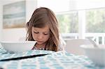 Girl at dining table looking down
