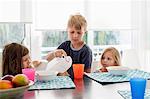 Big brother pouring milk into sisters plastic cup