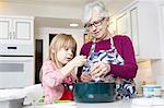 Girl and grandmother measuring salt for cooking