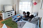 Three female friends relaxing at home, watching TV