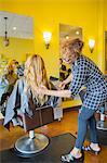 Stylist cutting woman's hair in hair salon