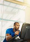 Determined man on elliptical trainer at gym