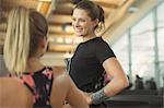 Smiling women talking at gym