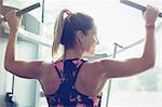 Fit woman doing lat pulldowns on equipment at gym