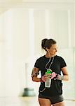 Smiling woman taking a break drinking water in gym studio