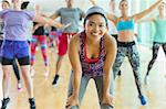 Portrait smiling woman resting with hands on knees in exercise class