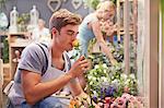 Florist smelling rose in flower shop