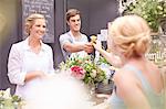 Florist giving woman rose in flower shop