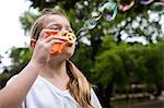 Girl blowing bubbles in the park