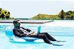 Businessman using laptop on inflatable