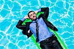 Businessman relaxing on inflatable