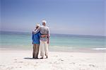 Rear view of senior couple embracing each other on the beach